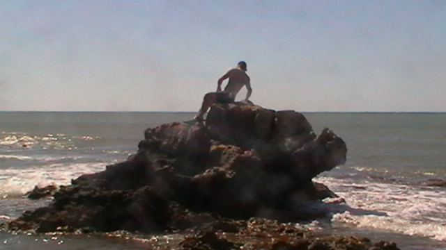 Patrick hat den Felsen im Meer erklommen